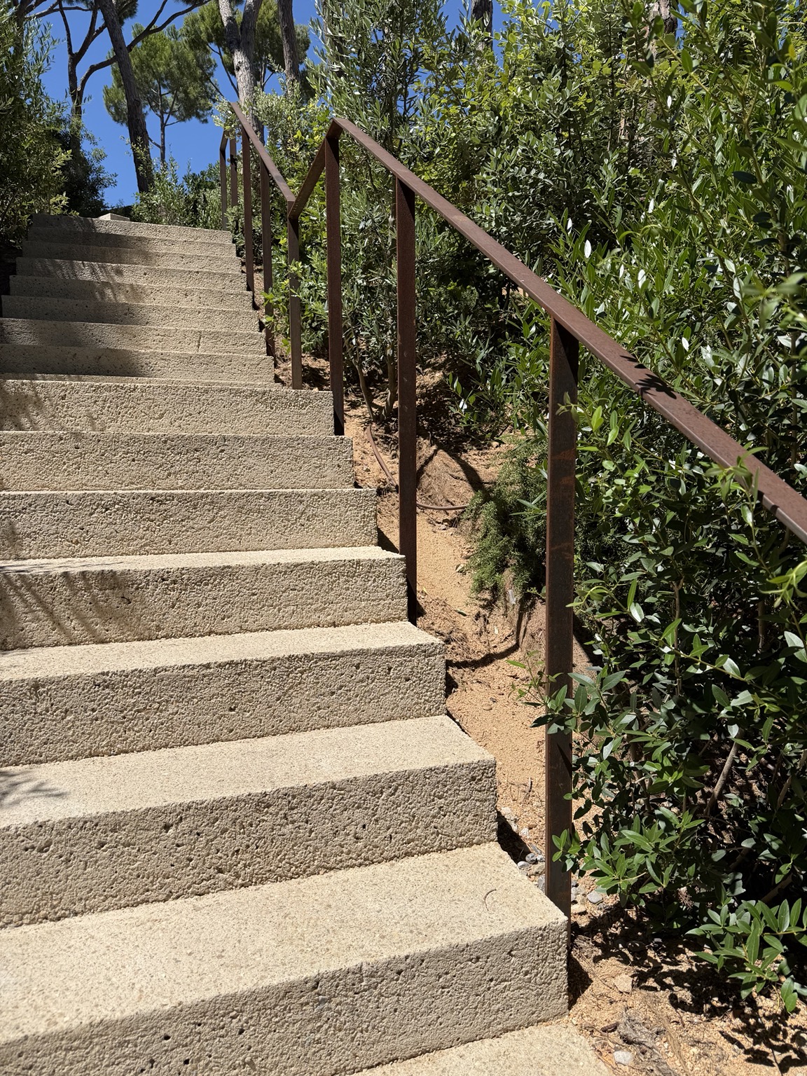Barandilla metálica junto a una escalera exterior de piedra