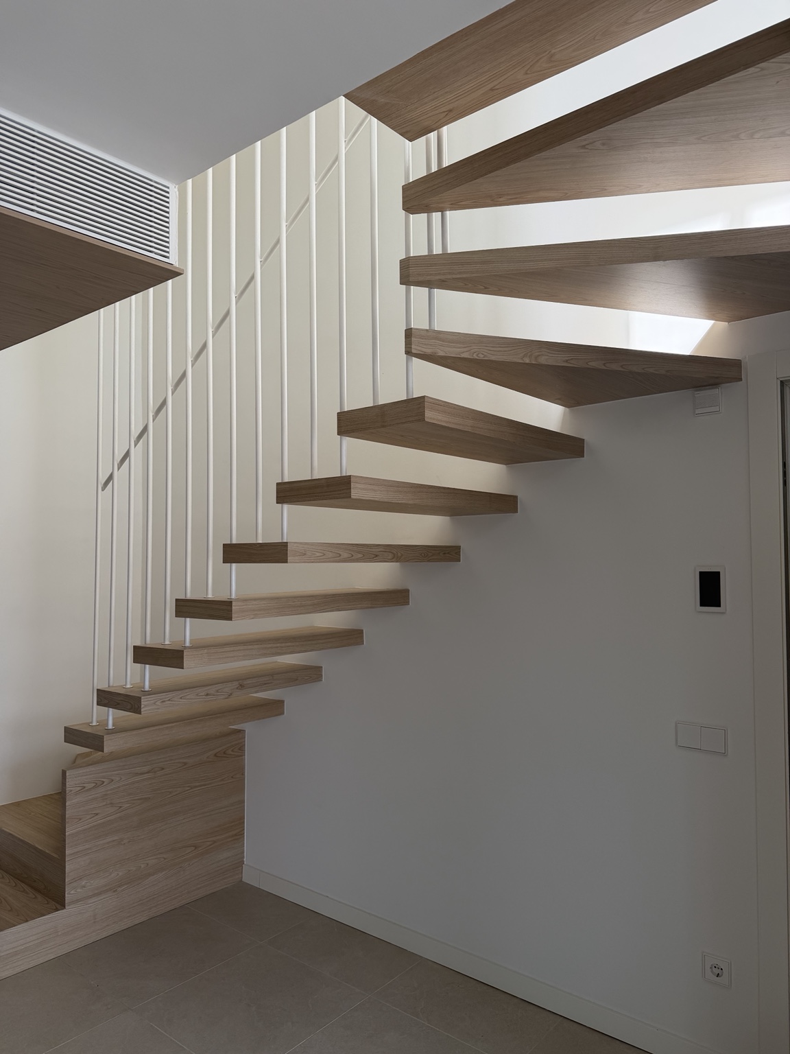 Escalera interior con peldaños de madera y estructura metálica